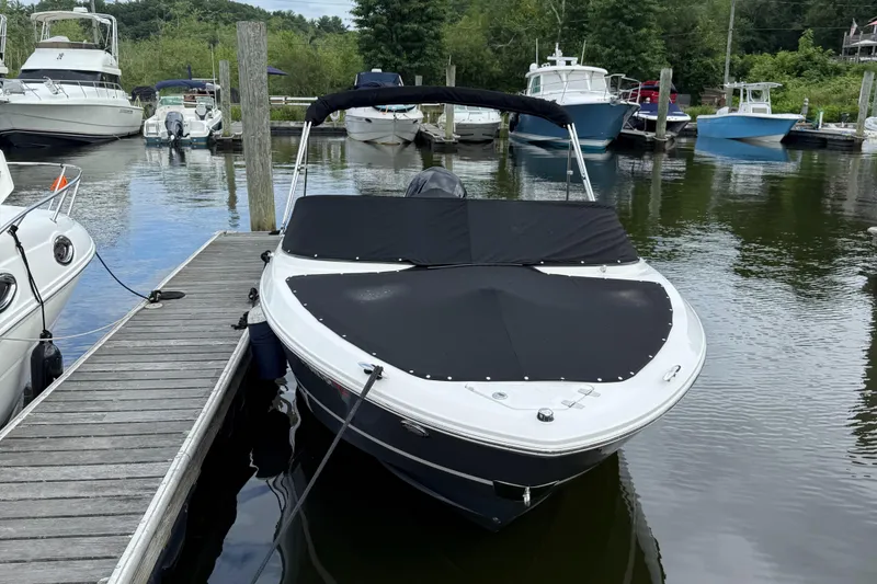 Slide: The Image of 2022 Regal LX2 boat docked at marina with cover on, surrounded by other boats. - 3