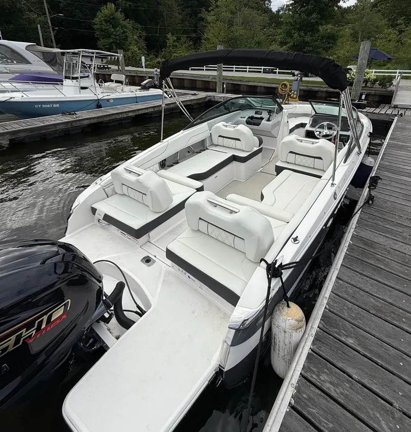 Slide: The Image of 2022 Regal LX2 boat docked, featuring spacious white seating and sleek design. - 4