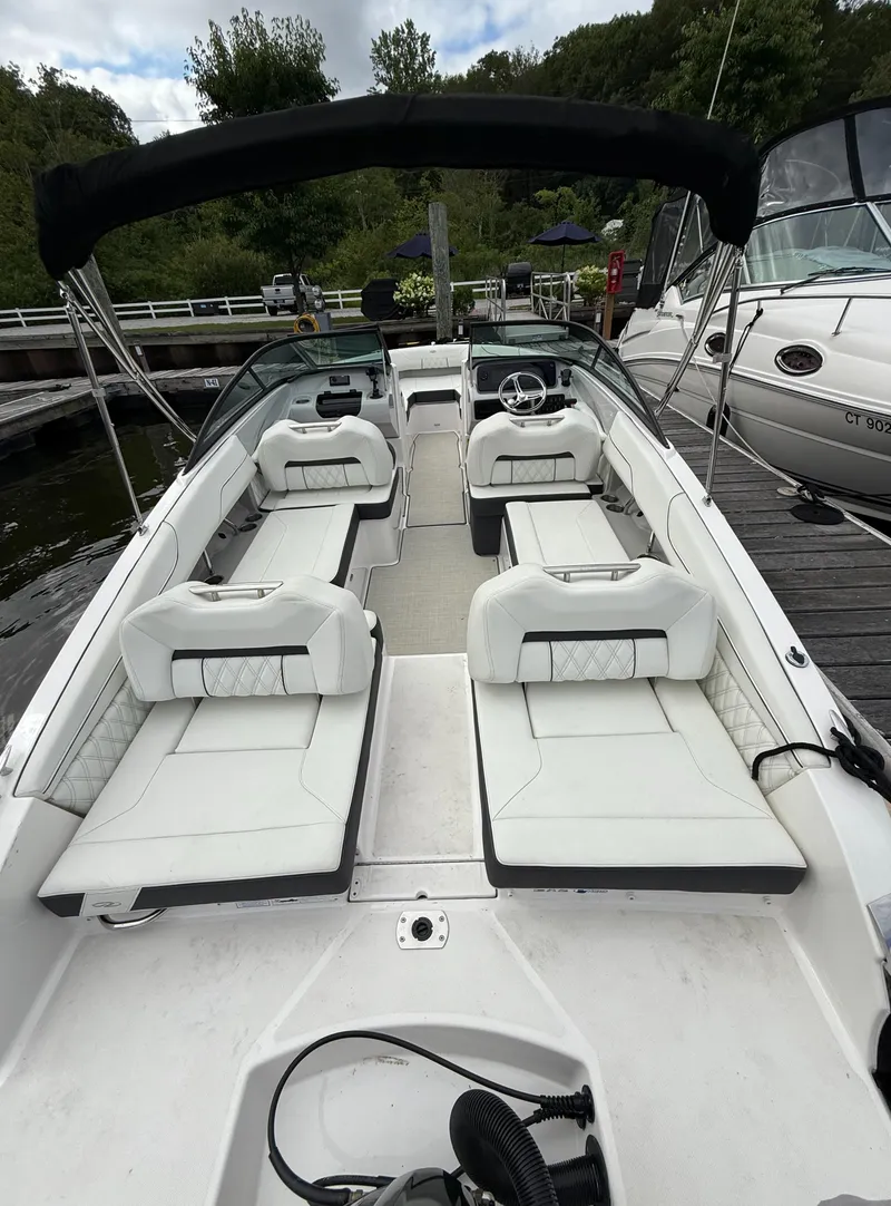 Slide: The Image of 2022 Regal LX2 boat with white seating, docked at a marina. - 6