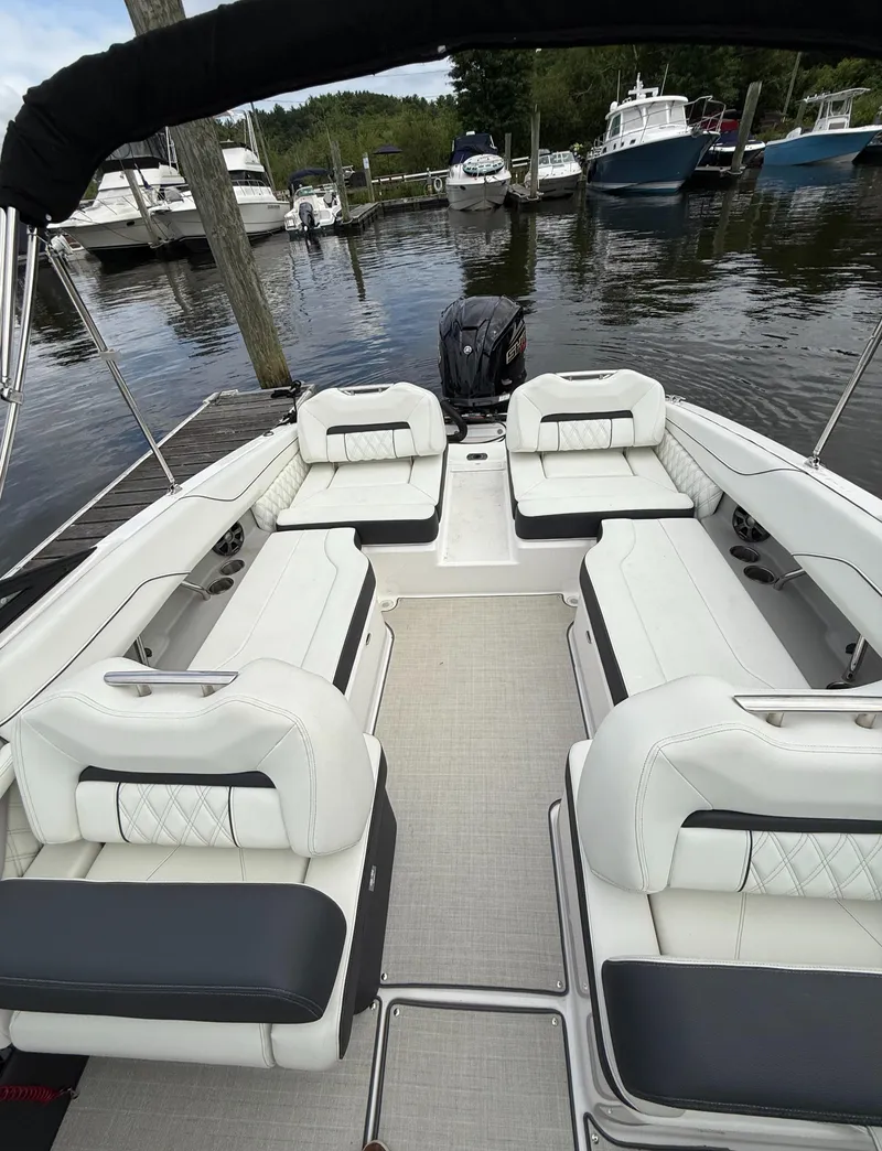 Slide: The Image of 2022 Regal LX2 boat interior with white seating, docked at a marina. - 8