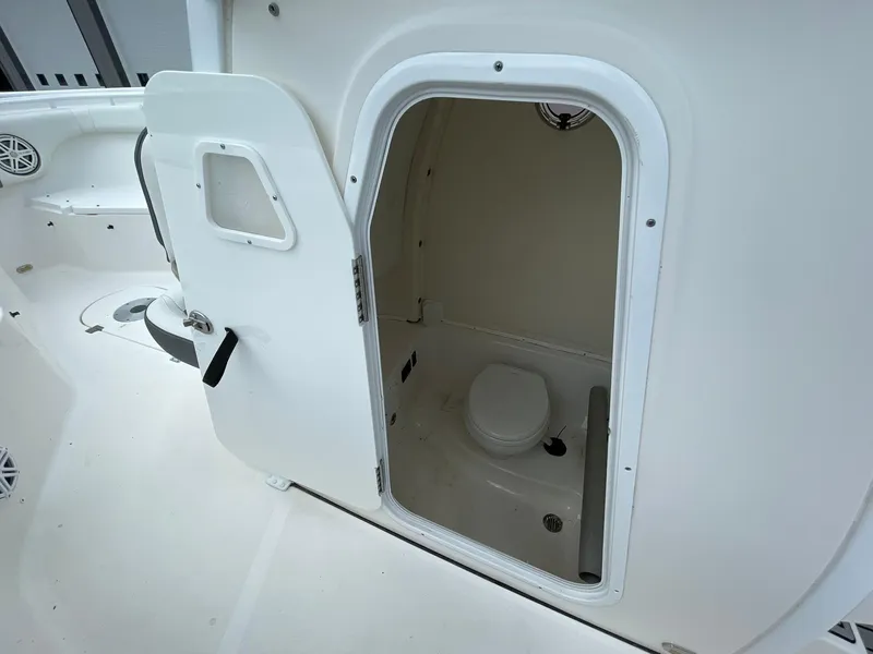 Slide: The Image of 2020 Tidewater 280 CC Adventure Custom boat interior with open door to compact bathroom. - 20