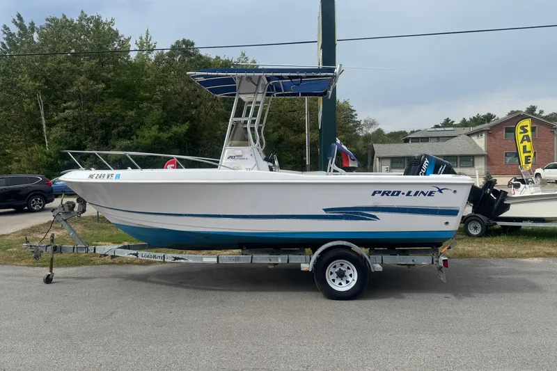 Slide: The Image of 2002 Pro-Line 20 Sport boat on trailer, parked outdoors near sale sign. - 4
