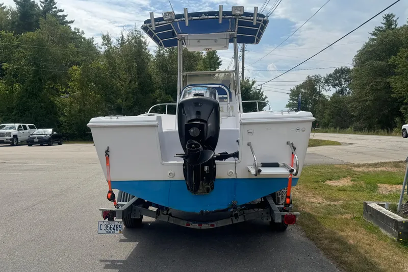 Slide: The Image of 2002 Pro-Line 20 Sport boat on trailer, parked outdoors with trees in background. - 5