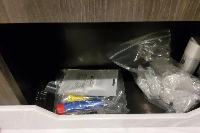 Slide: The Image of Storage compartment with various items in plastic bags on a Formula 380 Super Sport Crossover OB. - 120