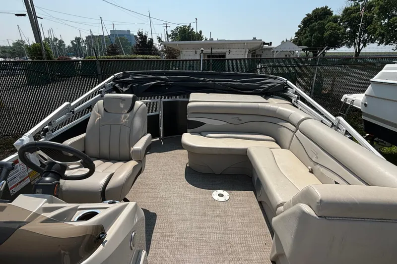Slide: The Image of 2019 Bennington 21 SLX pontoon boat interior with beige seating and steering wheel. - 4