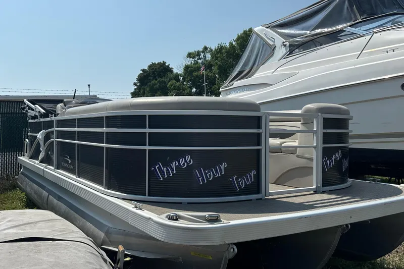 Slide: The Image of 2019 Bennington 21 SLX pontoon boat named "Three Hour Tour" docked beside another vessel. - 9