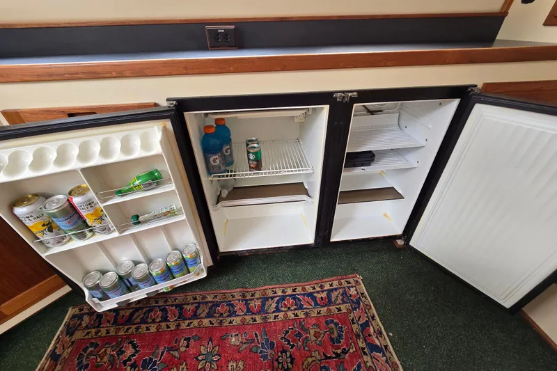 Slide: The Image of Interior of a 2001 Nordic Tug 32 showing open fridge with beverages. - 16