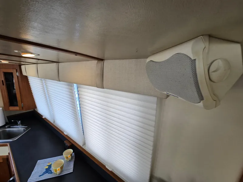 Slide: The Image of Interior of 2001 Nordic Tug 32 with blinds, speaker, and kitchen counter. - 21