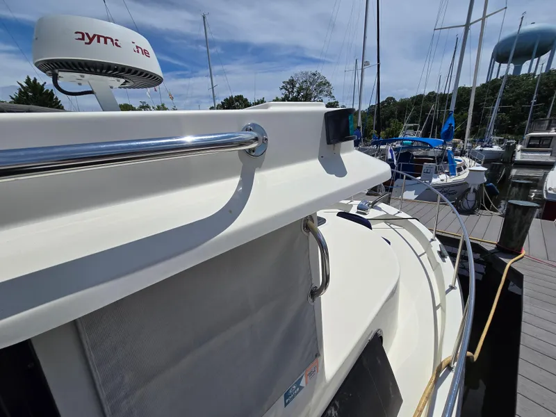 Slide: The Image of 2001 Nordic Tug 32 docked at marina, featuring sleek design and radar equipment. - 26