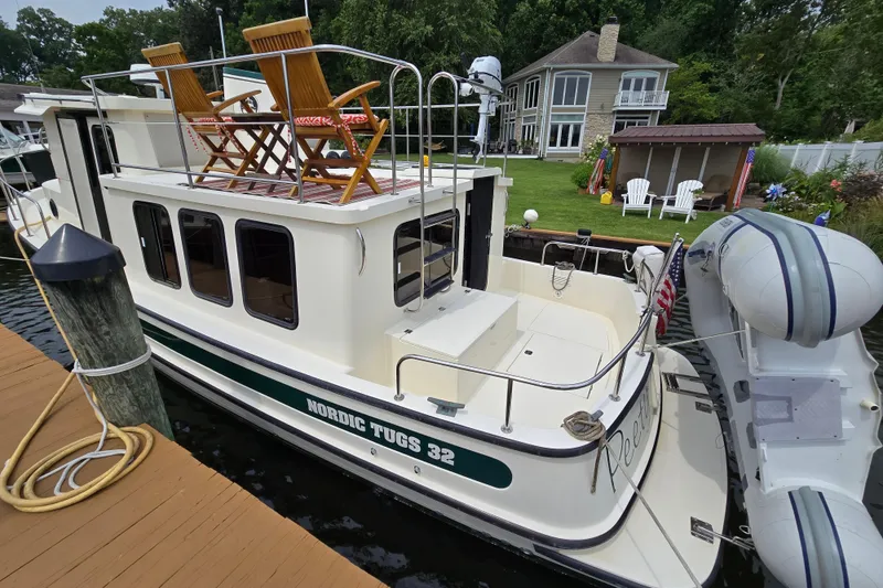 Slide: The Image of 2001 Nordic Tug 32 docked with upper deck chairs and inflatable boat. - 47