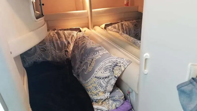 Slide: The Image of Cozy cabin interior of 1999 Sea Ray 270 with patterned pillows and soft lighting. - 4