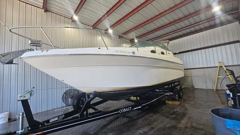 The Image of 1999 Sea Ray 270 boat on trailer in indoor storage facility. - 1