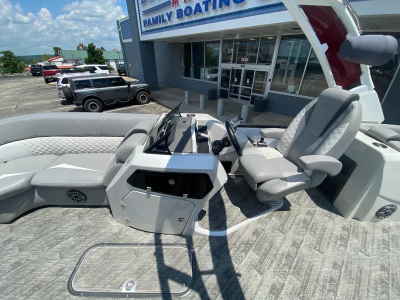 Slide: The Image of 2020 Manitou 25 Legacy SHP DL boat interior with luxurious seating and modern controls. - 11