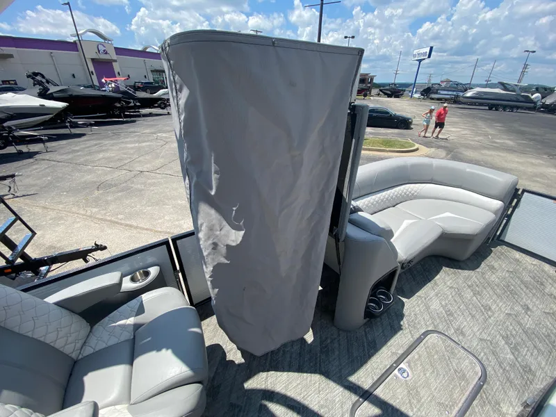 Slide: The Image of 2020 Manitou 25 Legacy SHP DL pontoon boat interior with gray seating and privacy curtain. - 13