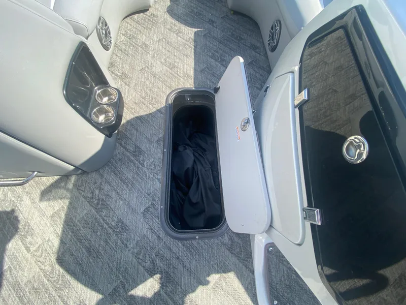 Slide: The Image of 2020 Manitou 25 Legacy SHP DL boat interior with open storage compartment. - 14