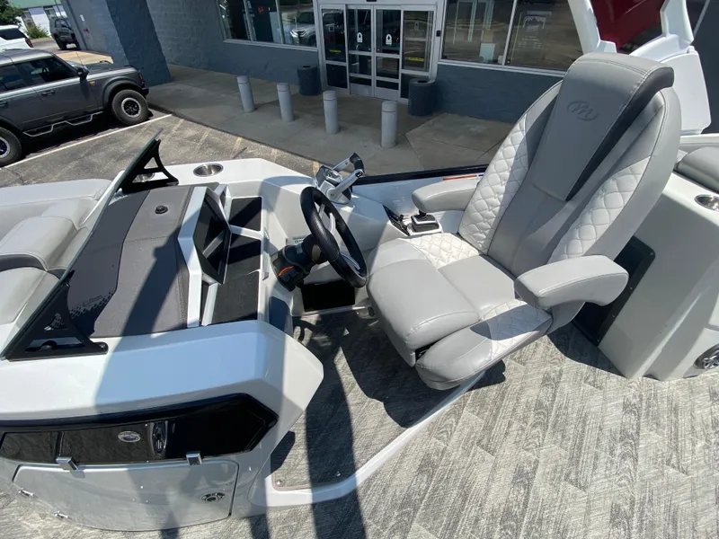 Slide: The Image of 2020 Manitou 25 Legacy SHP DL boat interior with steering wheel and captain's chair. - 16