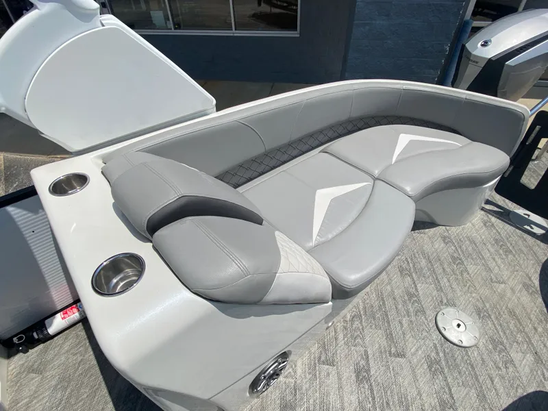 Slide: The Image of 2020 Manitou 25 Legacy SHP DL boat with luxurious gray seating and cup holders. - 26