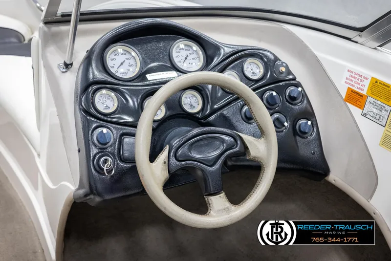 Slide: The Image of 2002 Tahoe Q3 I/O boat dashboard with steering wheel and gauges, Reeder-Trausch Marine logo. - 25