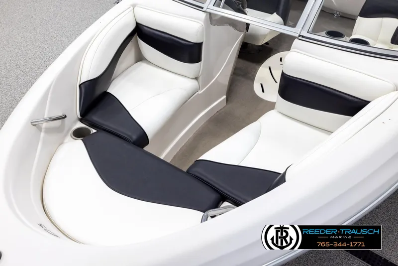 Slide: The Image of 2002 Tahoe Q3 I/O boat interior with white and black seating, cup holders, and steering console. - 9