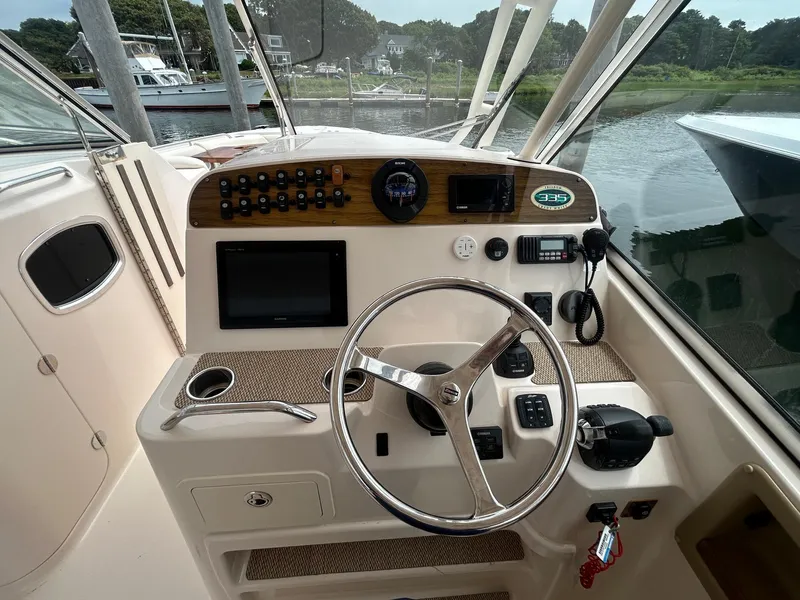 Slide: The Image of 2013 Grady-White Freedom 335 boat cockpit with steering wheel and control panel. - 16