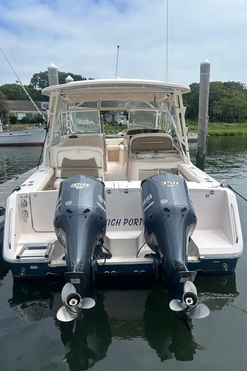 Slide: The Image of 2013 Grady-White Freedom 335 boat interior with beige seating at marina. - 18