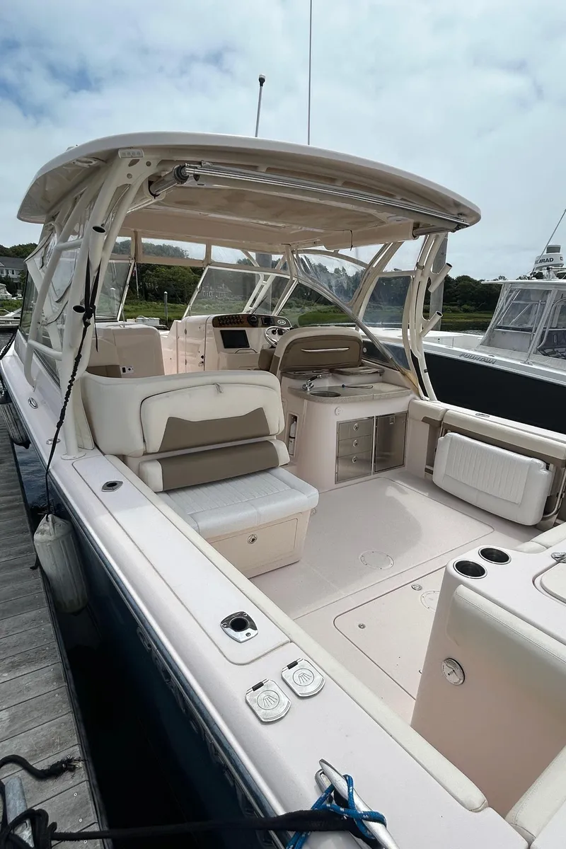 Slide: The Image of 2013 Grady-White Freedom 335 boat docked at marina, featuring spacious seating and sleek design. - 6