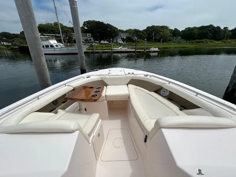 Slide: The Image of 2013 Grady-White Freedom 335 boat docked, featuring spacious seating and a wooden table. - 9
