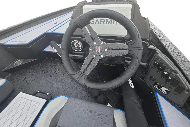 Slide: The Image of Steering wheel of 2026 Xpress H20 Bass boat with Garmin display, wet from rain. - 10
