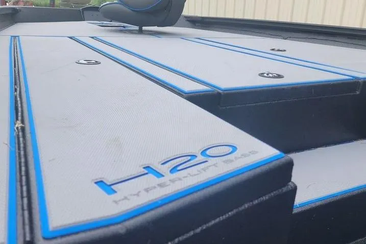 Slide: The Image of 2026 Xpress H20 Bass boat deck with blue accents and seating. - 18