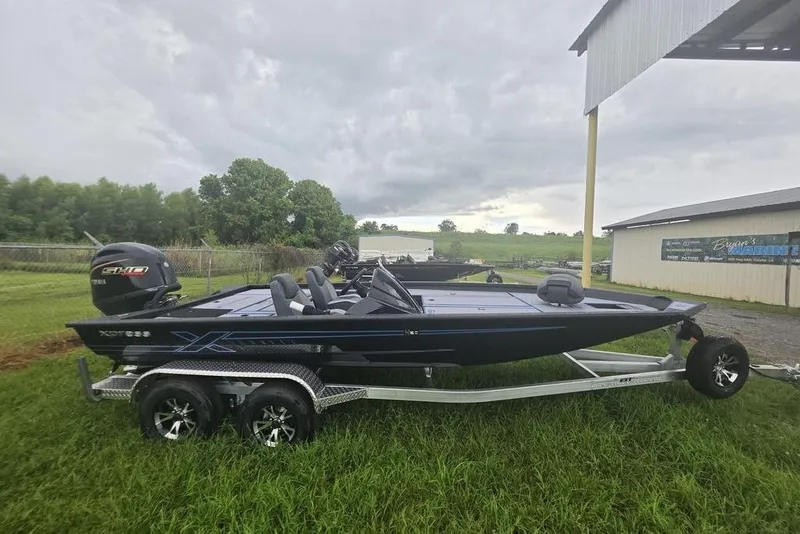Slide: The Image of 2026 Xpress H20 Bass boat on trailer, parked on grass under cloudy sky. - 20