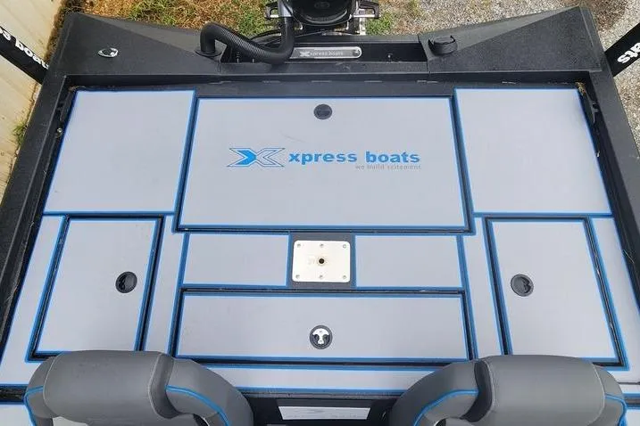Slide: The Image of 2026 Xpress H20 Bass boat deck with storage compartments and logo. - 30