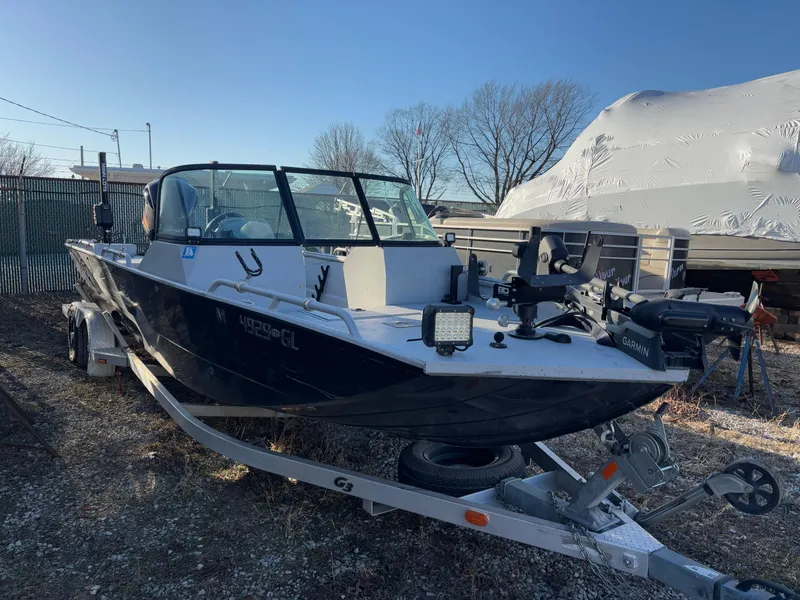 Slide: The Image of 2019 Sportsman 2400 G3 boat on trailer, equipped with Garmin technology, parked outdoors. - 12