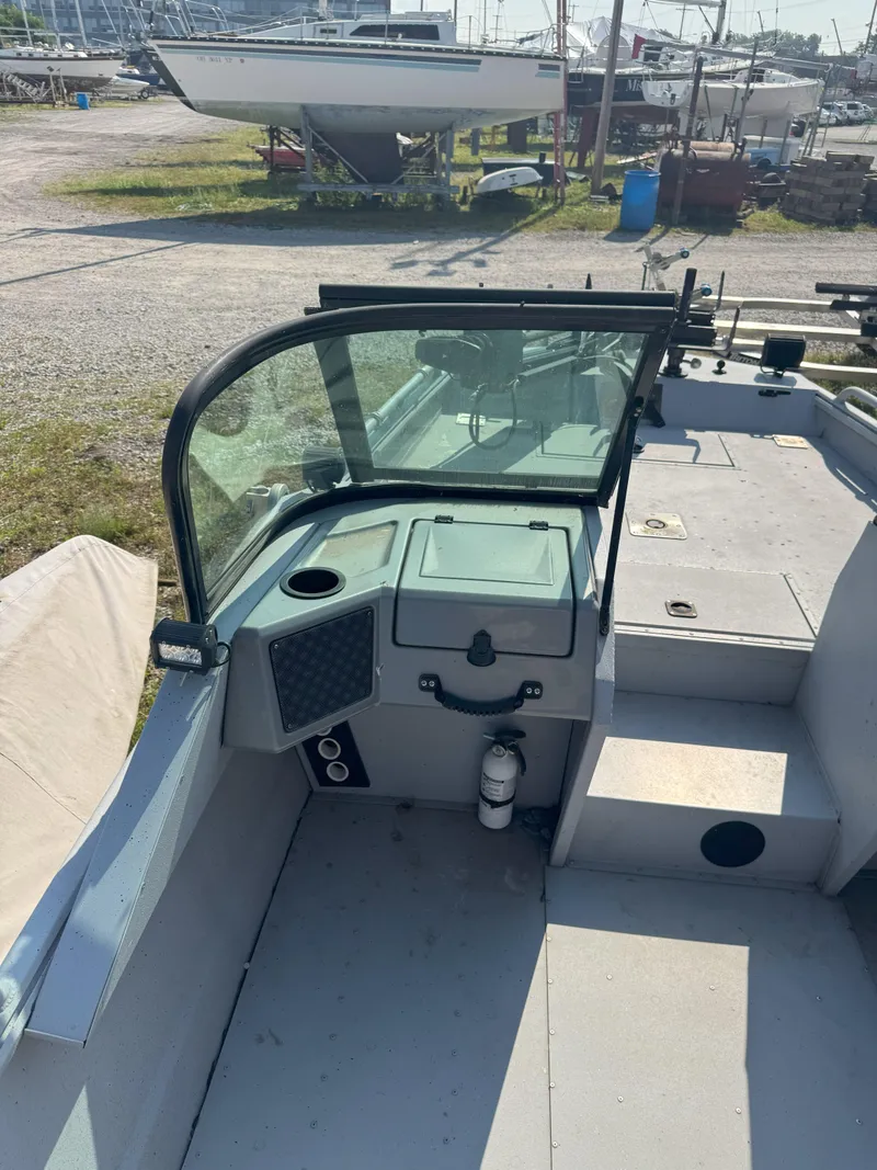 Slide: The Image of 2019 Sportsman 2400 G3 boat interior with windshield, control panel, and docked boats in background. - 5