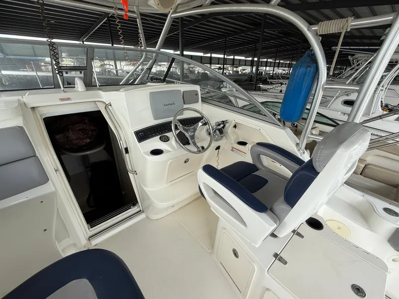 Slide: The Image of 2006 Boston Whaler 285 Conquest cockpit with steering wheel, Garmin display, and cushioned seating. - 11