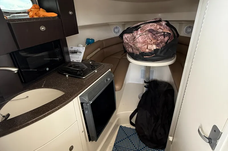 Slide: The Image of 2006 Boston Whaler 285 Conquest cabin interior with kitchenette and seating area. - 14