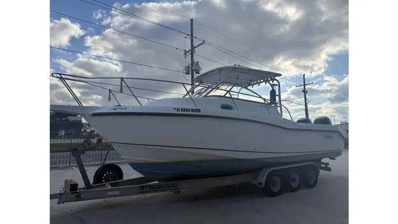 Slide: The Image of 2006 Boston Whaler 285 Conquest boat on trailer under cloudy sky. - 5