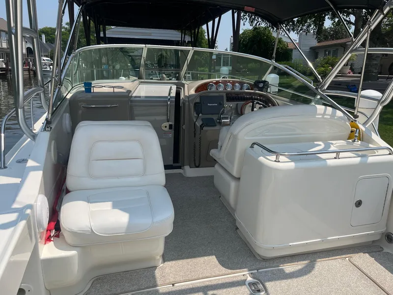 Slide: The Image of 2007 Sea Ray 290 Amberjack boat interior with white seating and steering console. - 11