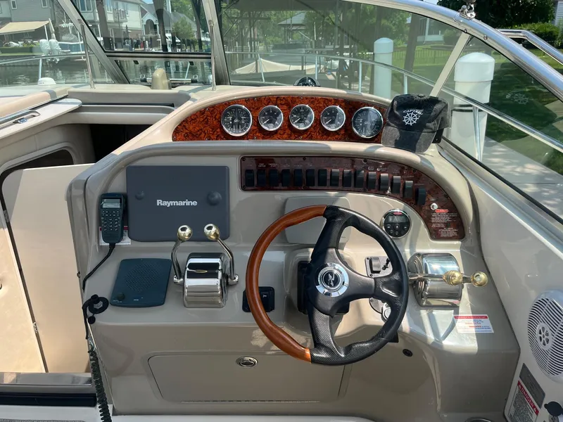 Slide: The Image of Helm of 2007 Sea Ray 290 Amberjack with steering wheel, gauges, and Raymarine electronics. - 13