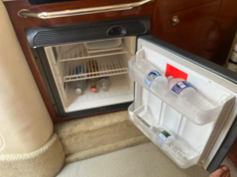 Slide: The Image of Open mini fridge on 2007 Sea Ray 290 Amberjack, stocked with water bottles and drinks. - 21