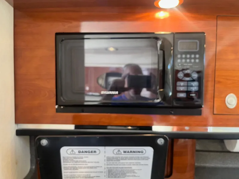 Slide: The Image of Microwave in 2007 Sea Ray 290 Amberjack boat interior with wood paneling. - 25