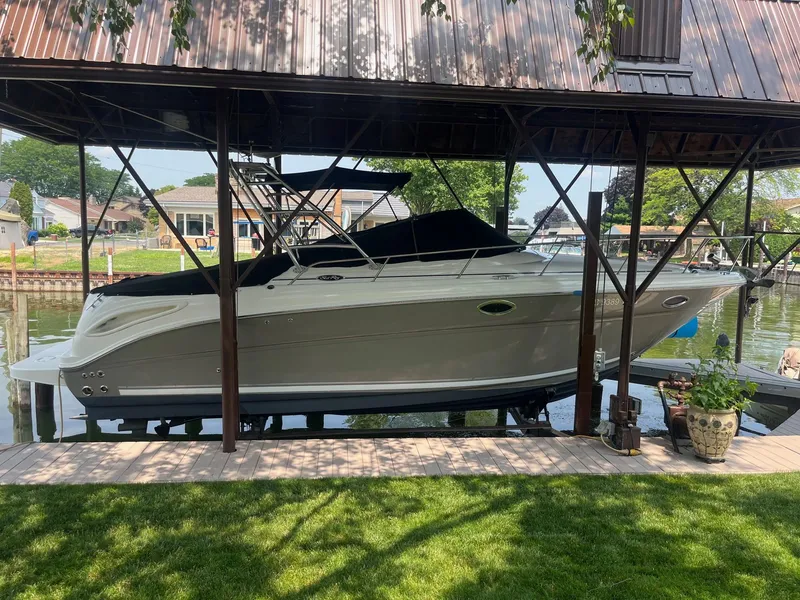 Slide: The Image of 2007 Sea Ray 290 Amberjack boat docked under a covered structure by the water. - 3