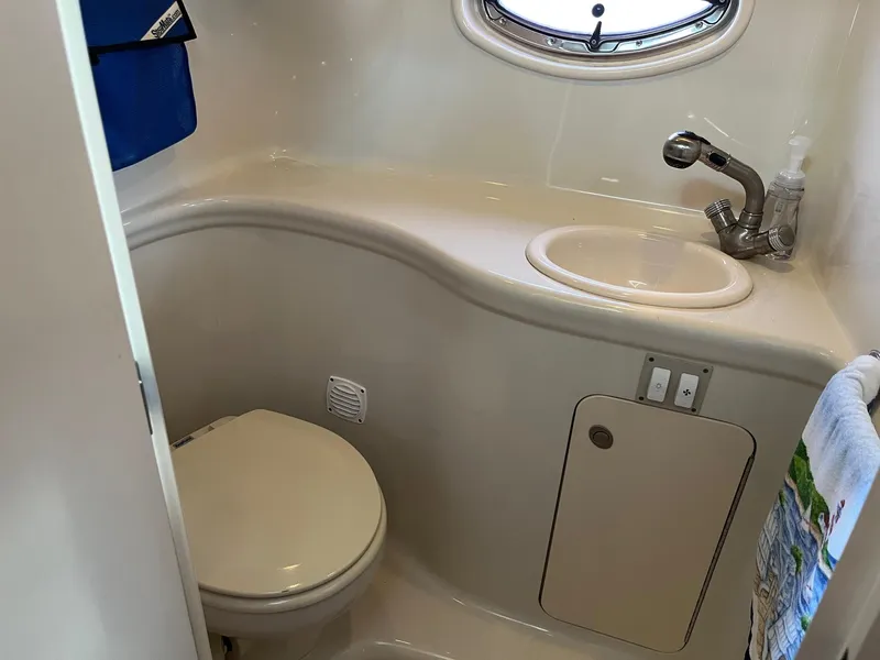 Slide: The Image of 2007 Sea Ray 290 Amberjack bathroom with sink, toilet, and porthole window. - 35