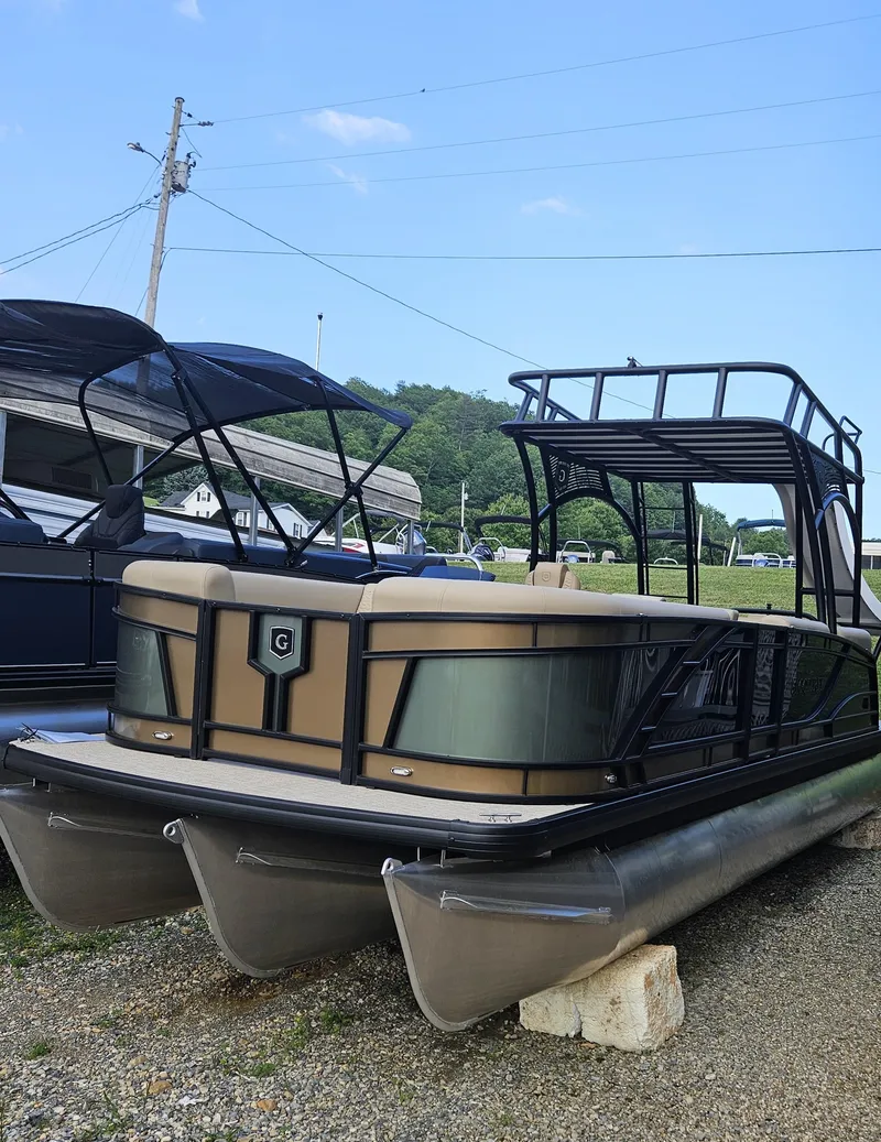 The Image of 2025 Godfrey MC255 SD pontoon boat with canopy, parked on gravel. - 1