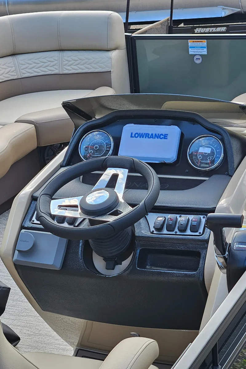 Slide: The Image of 2025 Godfrey MC255 SD boat dashboard with steering wheel and Lowrance display. - 10
