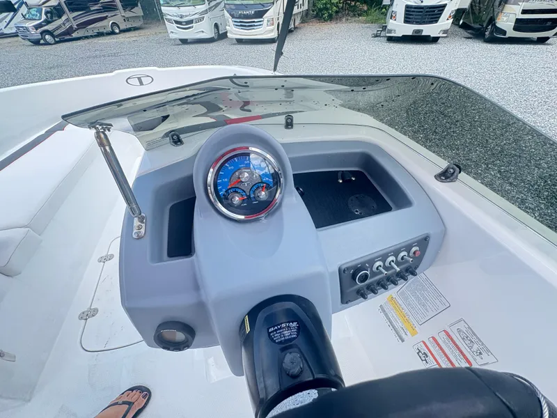 Slide: The Image of 2021 Tahoe T16 boat with red canopy and Mercury outboard motor in a gravel lot. - 3