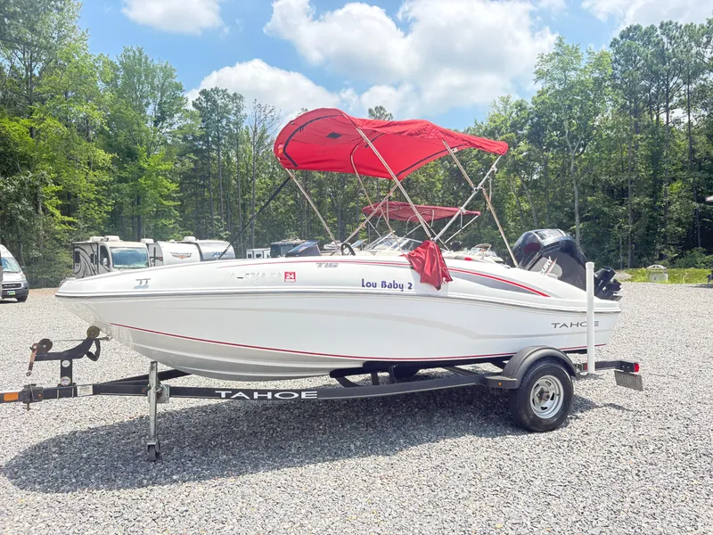 Slide: The Image of 2021 Tahoe T16 boat interior with cushioned seating and outboard motor. - 9