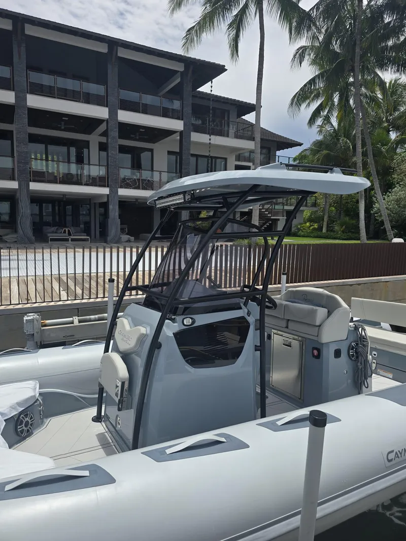 Slide: The Image of 2025 Ranieri CAYMAN 26 SPORT TOURING boat docked near a modern waterfront home. - 17