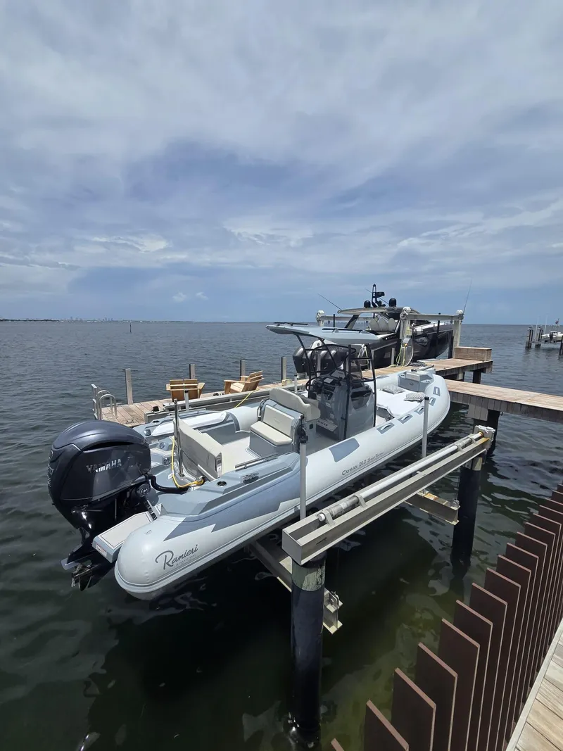 Slide: The Image of 2025 Ranieri CAYMAN 26 SPORT TOURING boat docked on a lift by the water. - 2