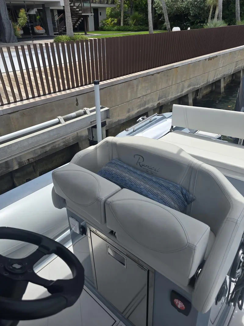 Slide: The Image of 2025 Ranieri CAYMAN 26 SPORT TOURING boat interior with steering wheel and cushioned seating. - 26