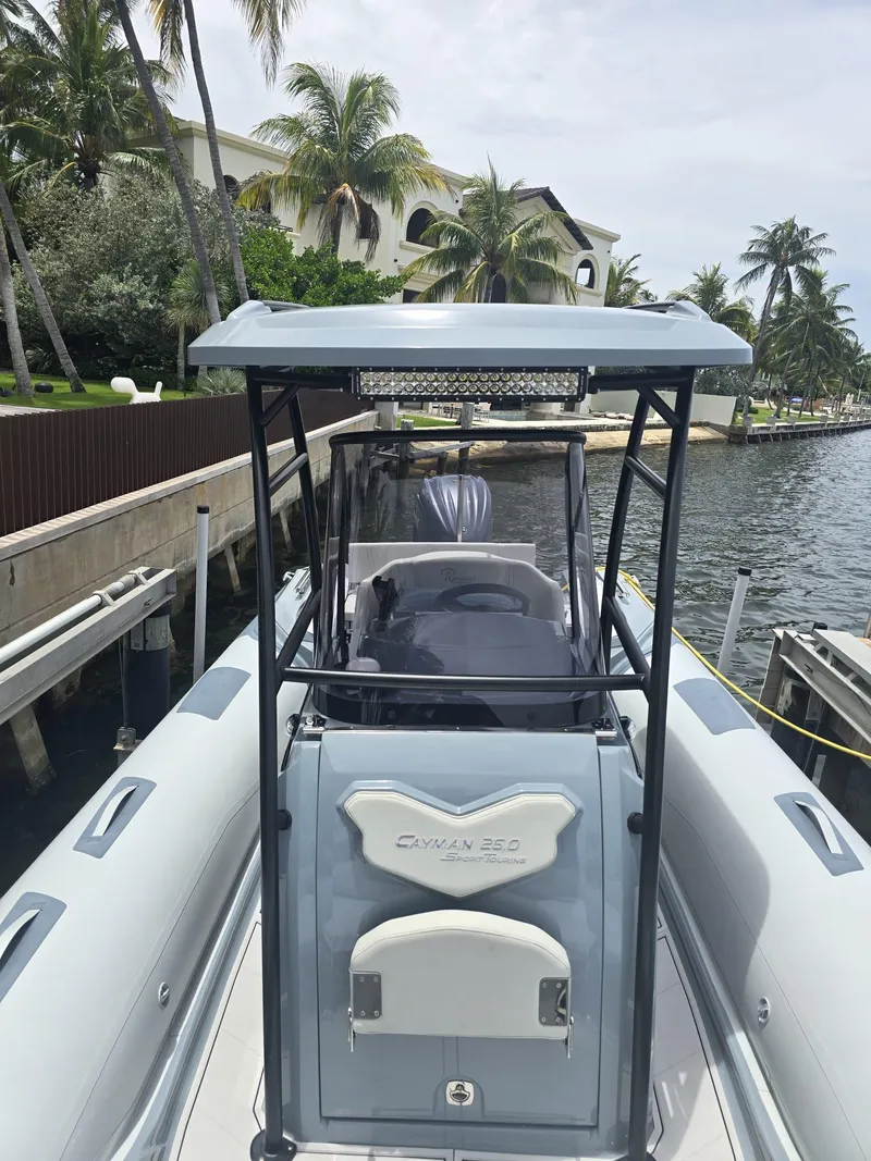 Slide: The Image of 2025 Ranieri CAYMAN 26 SPORT TOURING boat docked by palm trees and waterfront. - 29